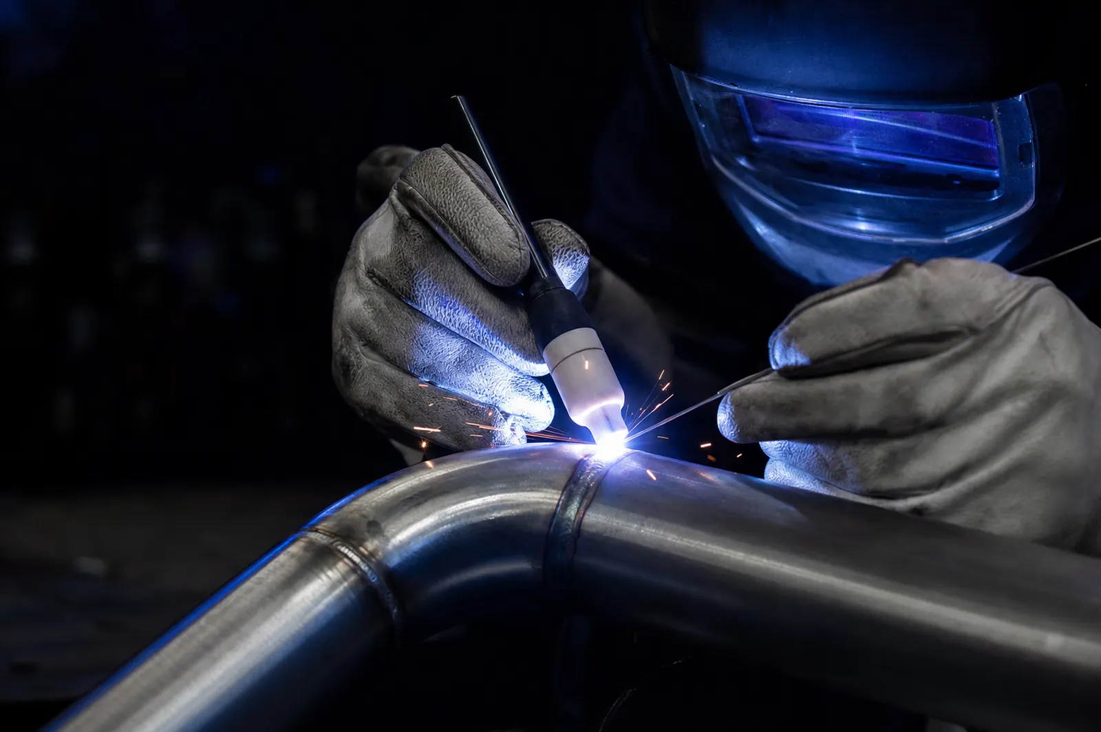 TIG welding a stainless steel pipe joint, bright arc light and sparks